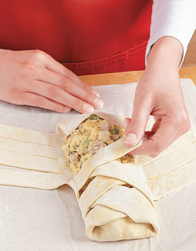 Fold up the flaps at both ends, then braid the strips across the filling. Brush pastry with egg wash.