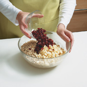Use a wooden spoon to vigorously work the oats, cranberries, and white chocolate into the dough. 