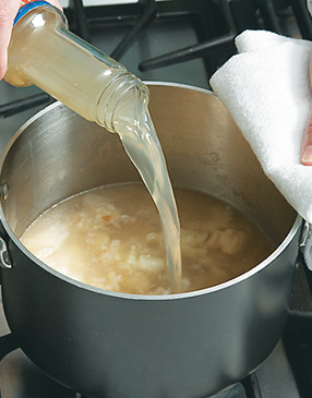 Deglaze the pot with clam juice, scraping up brown bits from the bacon and vegetables for extra flavor.