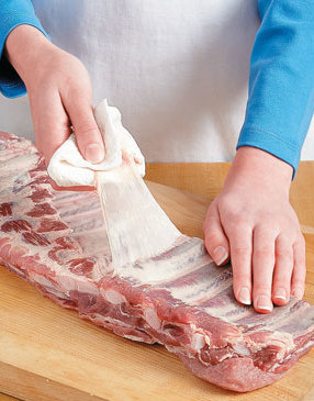 The membrane must be removed prior to cooking the ribs. Grip it with a paper towel and pull it off.
