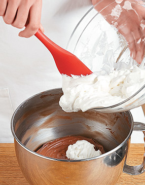 To avoid deflating whipped cream, gently fold it in with a spatula just until no streaks remain.