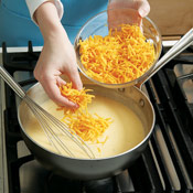 Add the Cheddar in stages, whisking after each addition until cheese is completely melted into the base.