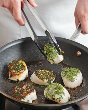 The skillet should be hot at first to get a crust on the scallops, then turn the heat down to medium.