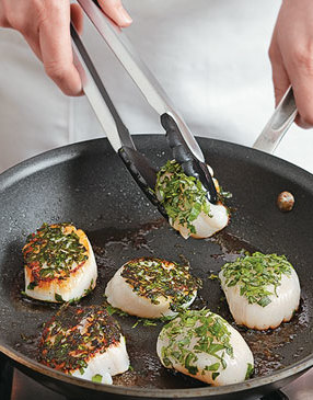 The skillet should be hot at first to get a crust on the scallops, then turn the heat down to medium.