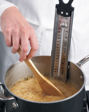 Stir caramel occasionally with a wooden spoon until syrup reaches 250° F on candy thermometer.