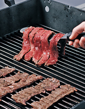 For convenience, use a large offset spatula to quickly and easily flip multiple steak strips at a time.