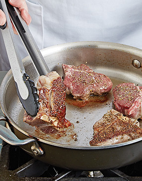 The chops are done searing and ready to be flipped when they easily unstick from the pan.