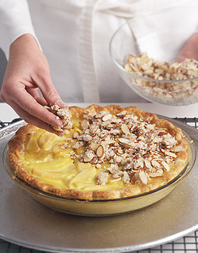 Once the custard begins to set, top the pie with the sugared-almond mixture. Continue baking.