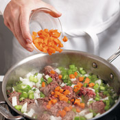 Brown the ground beef in butter, breaking up meat with a wooden spoon, then add vegetables.