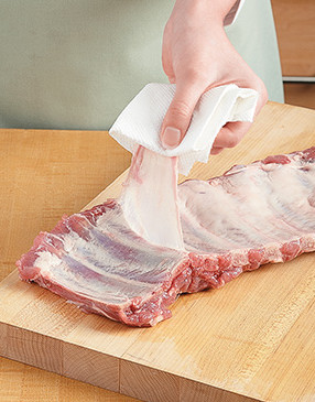 Remove the membrane by pulling it with a paper towel. It must be removed before cooking or grilling.