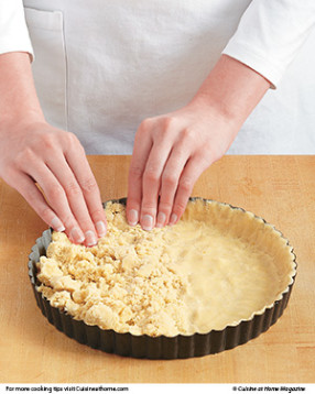 Press the dough evenly on the bottom and up the sides of the tart pan, dock, then bake.