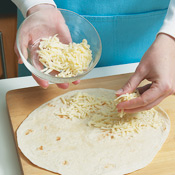 Assemble quesadillas, sprinkling ½ cup cheese on half of each tortilla, then folding over.