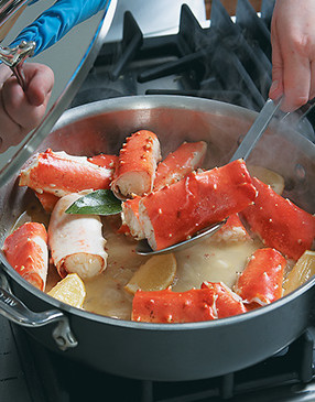 Use a slotted spoon to remove the crab, lemon wedges, and bay leaf from the pan, leaving all the flavorful juices behind.