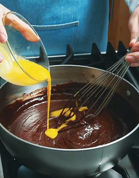 Combine egg yolk with vanilla, then whisk into melted chocolate mixture. Cook 2 minutes.
