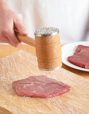 Although swissing usually requires the jagged edge of a mallet, use the flat edge to pound out this steak.