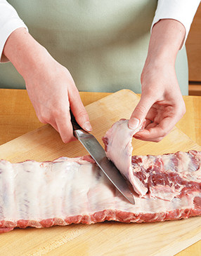 St. Louis-style ribs require minimal prep work. Start by cutting off excess fat from both sides.