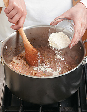 To prevent clumping, stir in the flour until thoroughly mixed. It will thicken the soup just slightly.