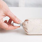 Tightly twisting ends of the parchment forms the butter into a firm mass, which makes it easy to slice and serve.