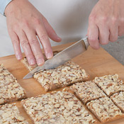 Loosen the foil from edges, then slide cookie off the foil onto a cutting board. Trim edges (<em>optional</em>); cut into eighths, then quarter each eighth to make 32 bars.