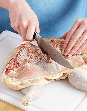 With a knife, make a small slit in the center of the keel bone, then bend breasts back to spread the cut.