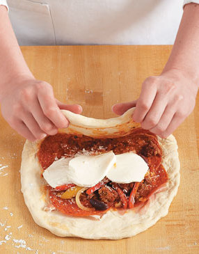 Stretch the dough up and over the filling, carefully pulling it to cover without tearing the dough.