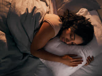 Kvinna sover på sidan i säng