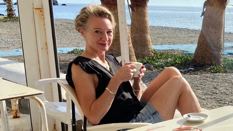 Lovisa njuter av en kopp kaffe på stranden.