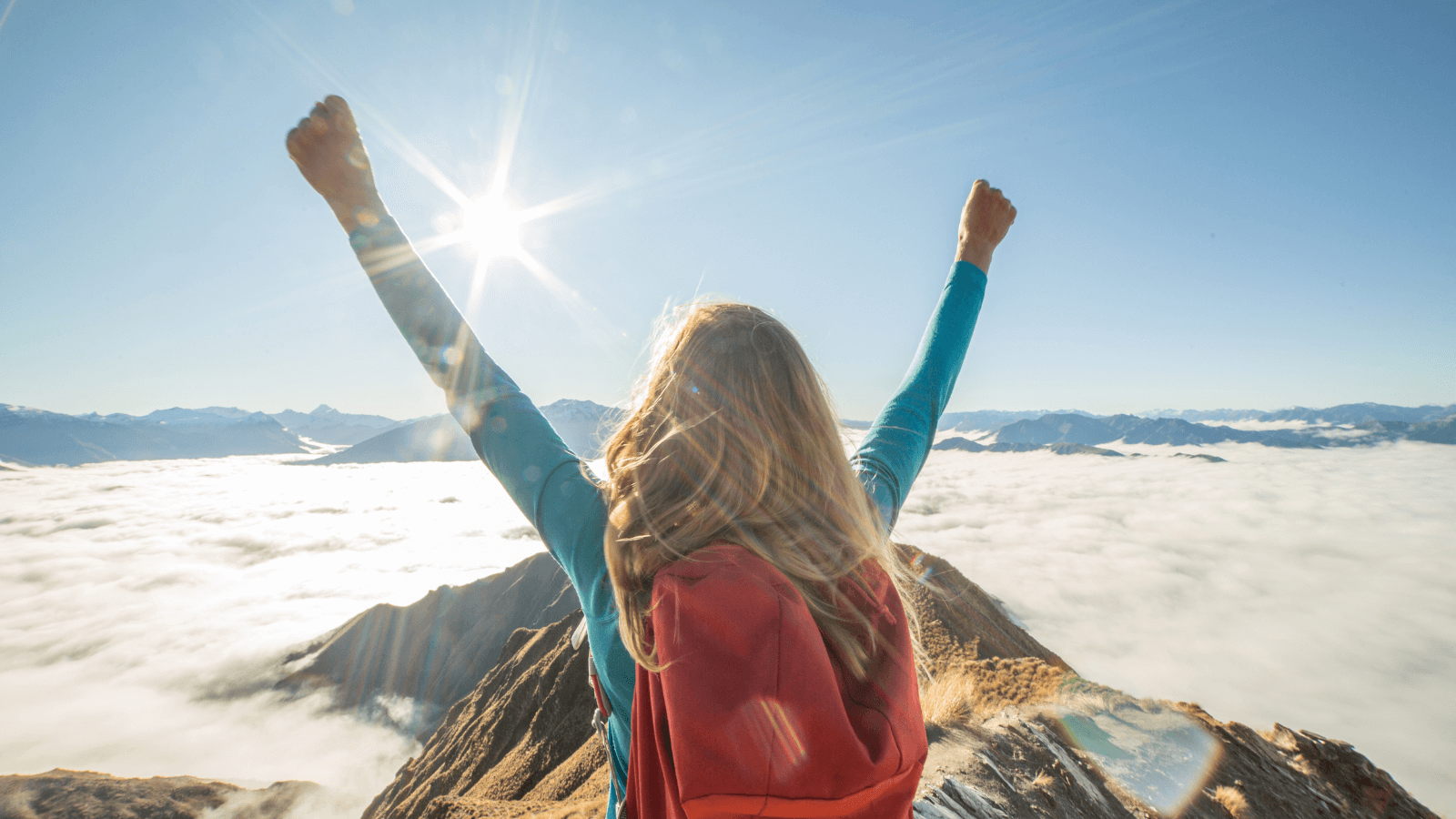 Kvinna kikar över bergen och känner sig som en vinnare.