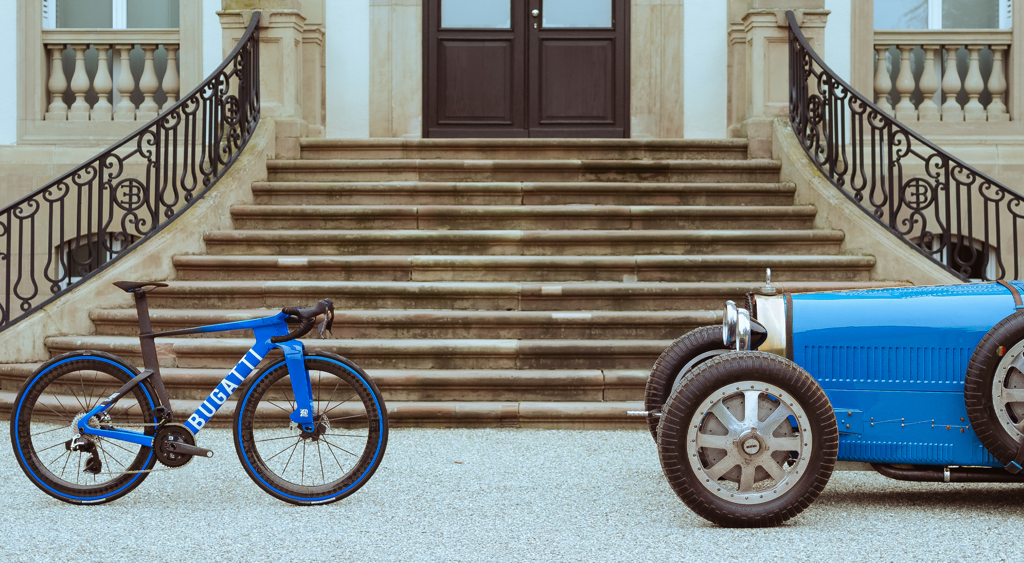 Side view of a Bugatti Factor ONE facing a Bugatti Type 35 automobile standing in front of the steps of the Chateau Saint Jean, the home of Bugatti.