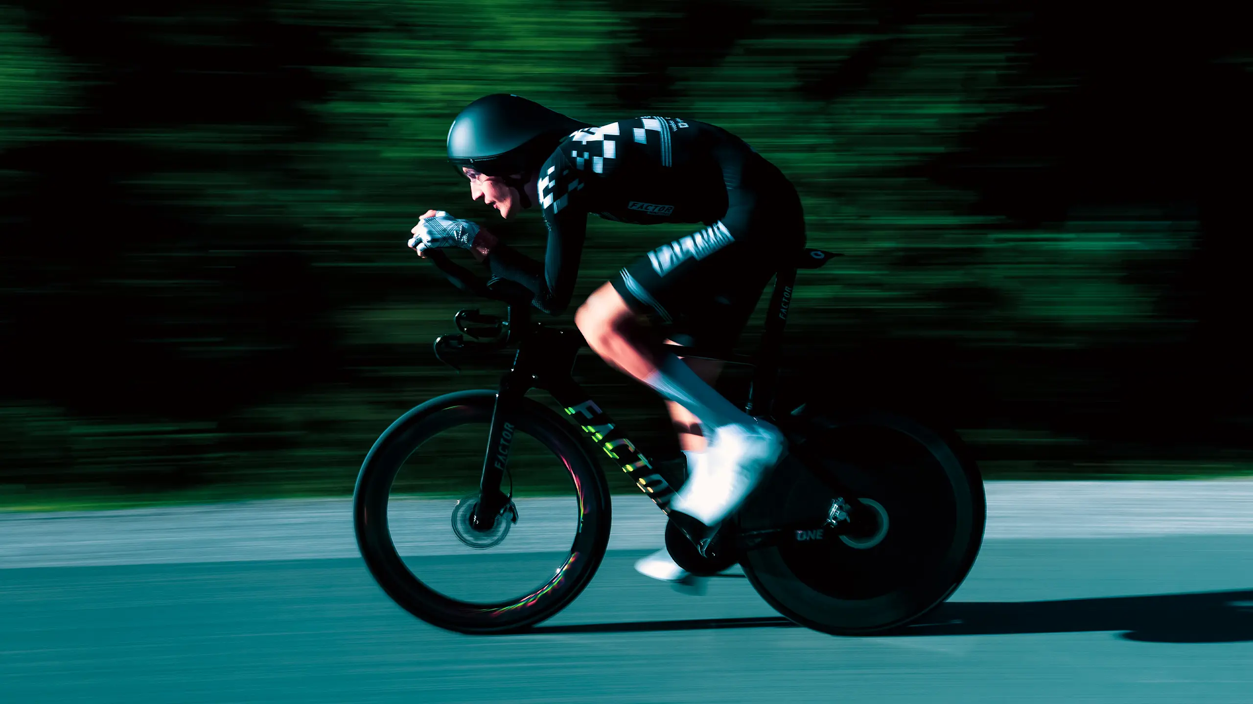 Non-drivetrain side view of a Factor Racing athlete on the ONE SP in Chrome. The image is slightly out of focus denoting speed.