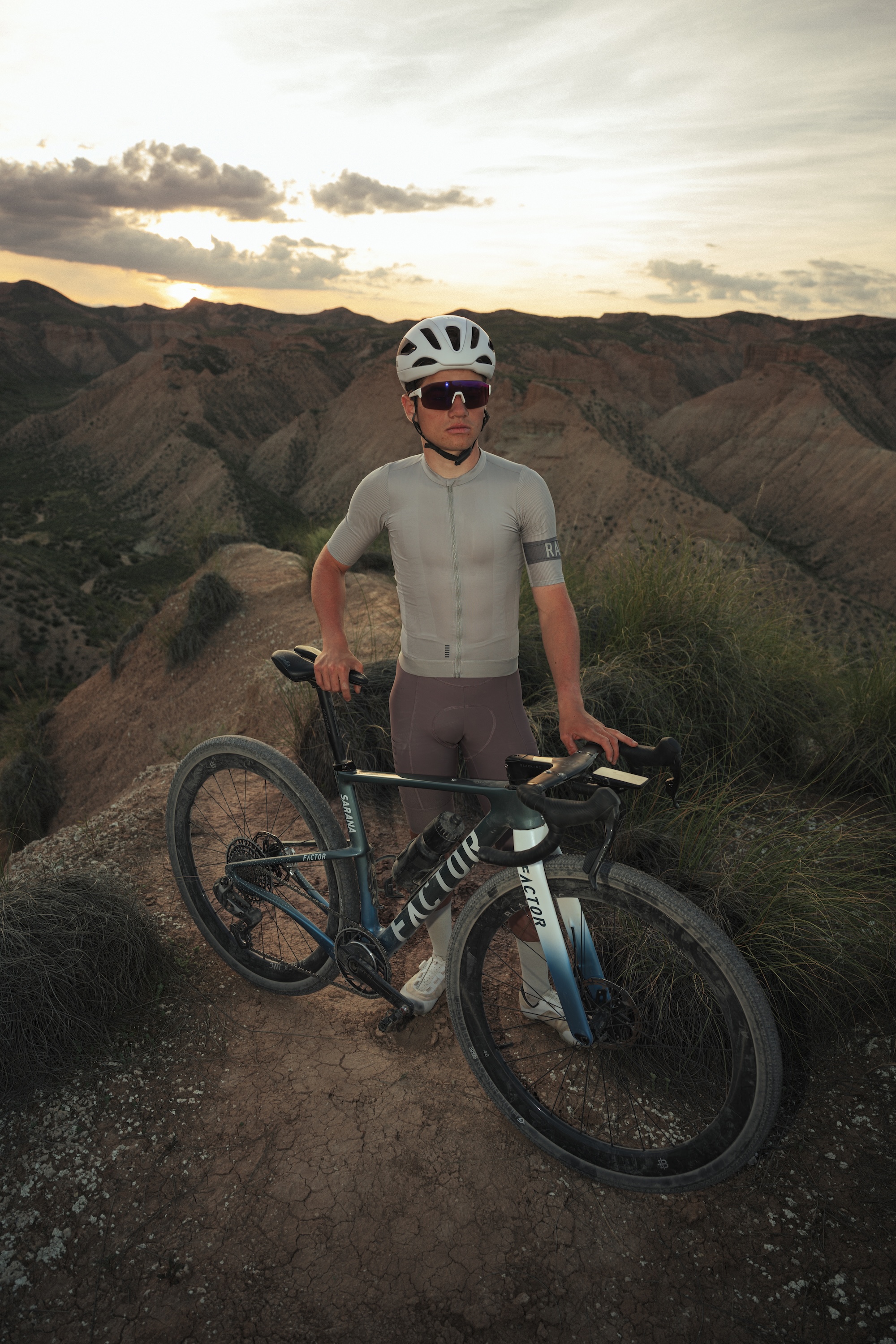 Victor Bosoni stands with his Factor SARANA Gravel bike in front of a desert landscape