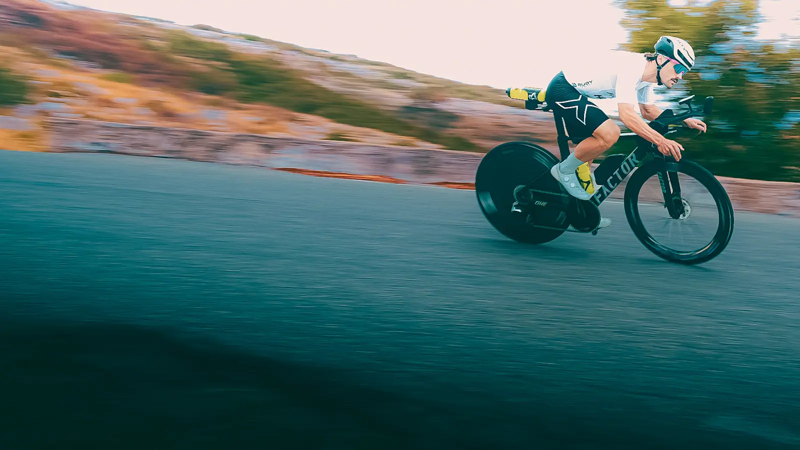 Off-centred drivetrain side view of a Factor athlete racing the ONE SP. The background is out of focus to indicate the speed.