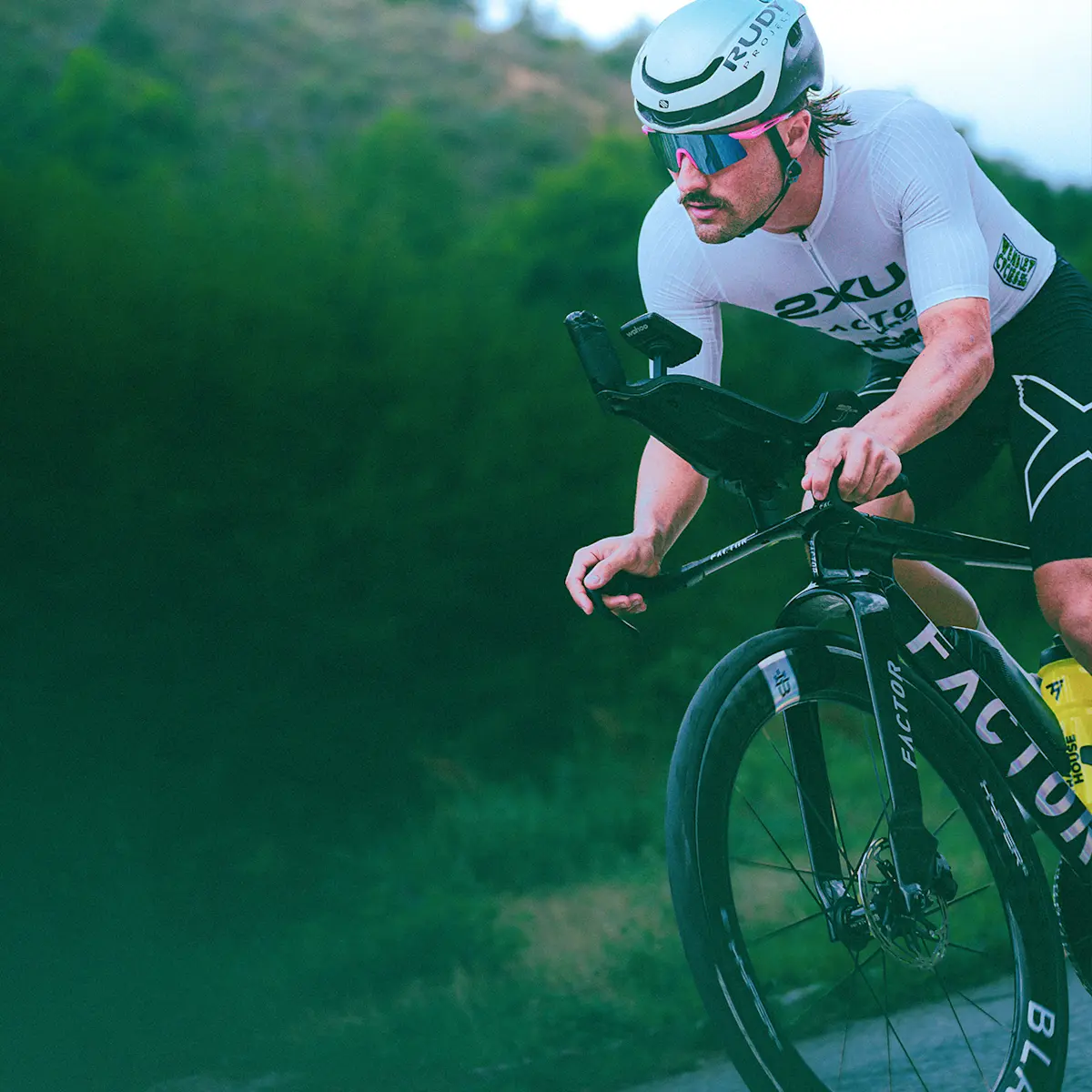 Slightly off-centred obliquely angled side view of a Factor athlete racing the ONE SP holding onto the basebar grips. 