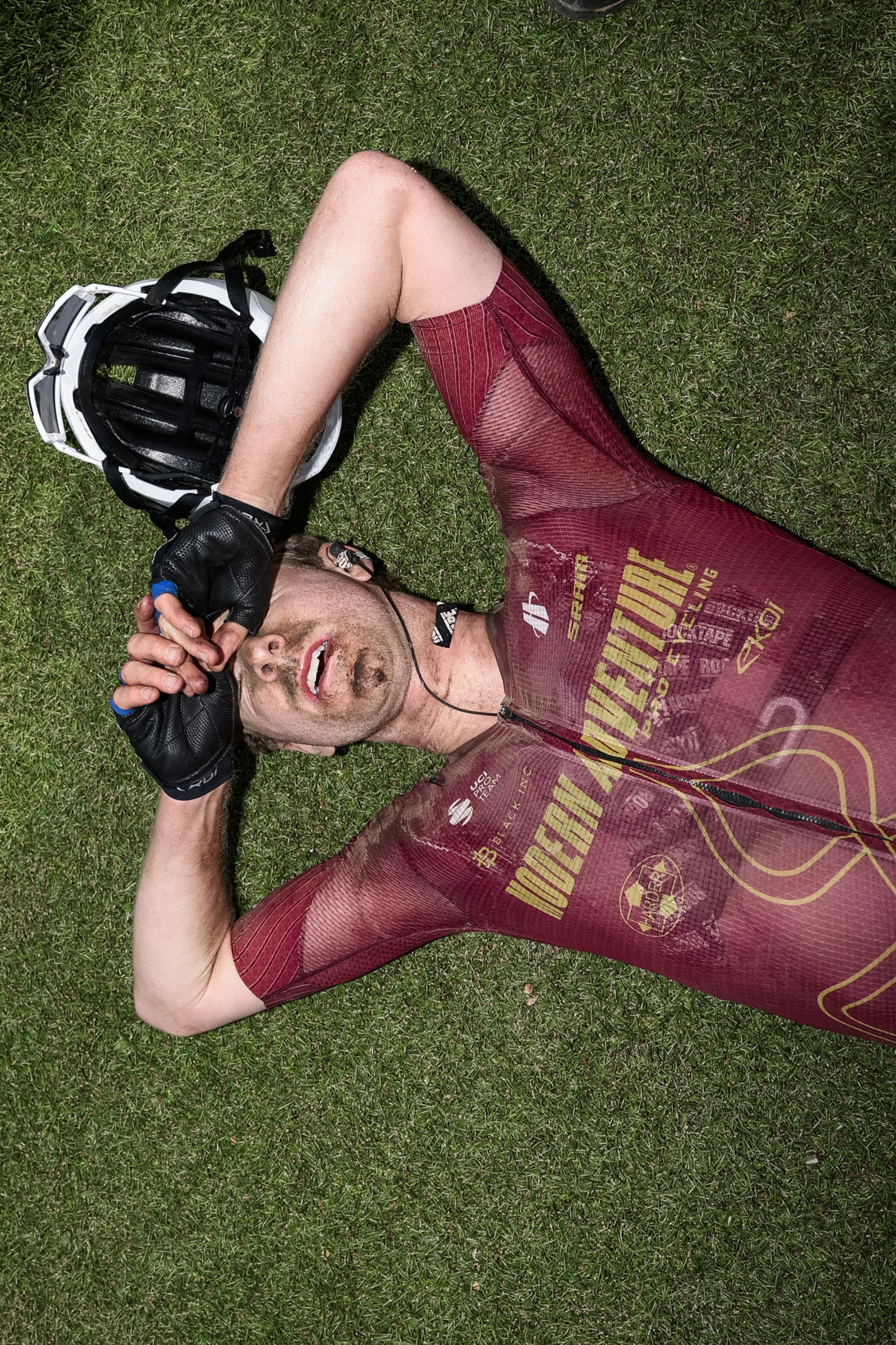 Modern Adventure Pro Cycling rider lying on the ground in the velodrome after finishing Paris Roubaix