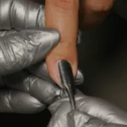 Gently glide the cuticle pusher along the nail, removing softened cuticle from the nail plate