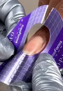 Holding the form at a 45° angle, slip the form under the edge of the natural nail