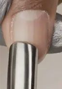 Gently glide a cuticle pusher along the nail plate