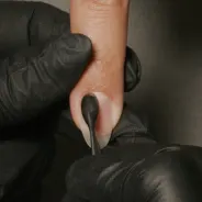 Gently glide a cuticle pusher along the nail plate