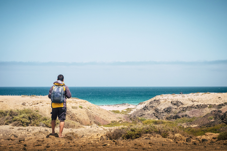 man with backpack at beach