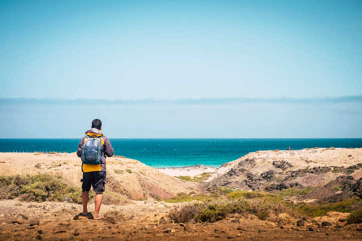 man with backpack at beach