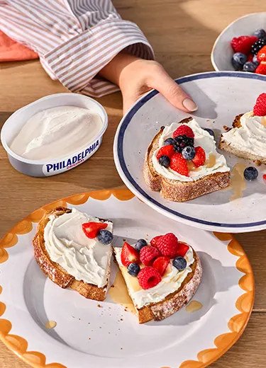 Frühstücksteller mit Toast, belegt mit Philadelphia Frischkäse, Heidelbeeren und Erdbeeren