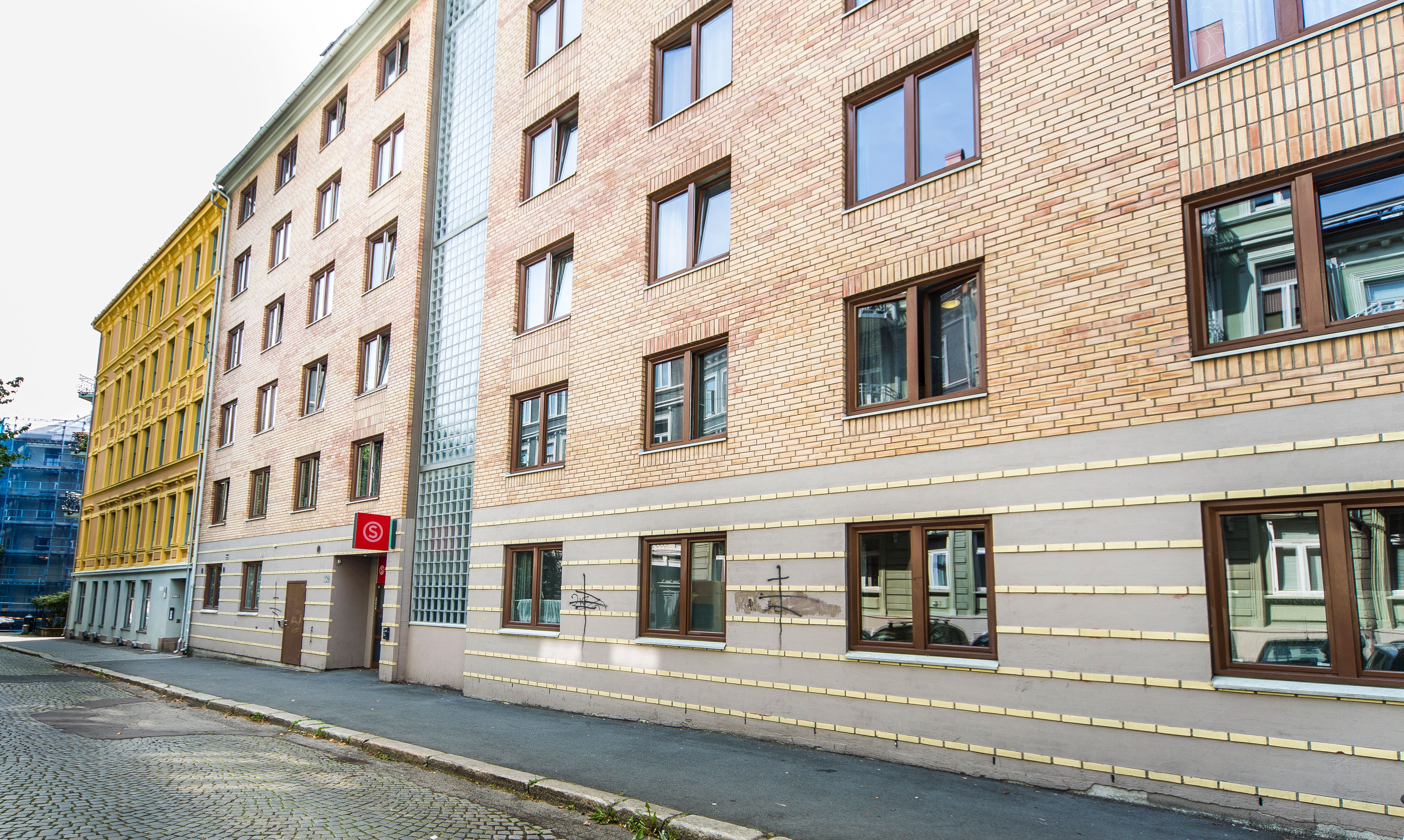 A picture of Sofienberg Student Village. The building is a yellow brick structure located along a street.
