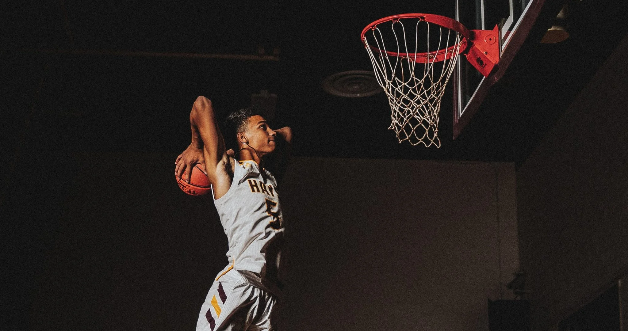 A basketball player one split second before a slam dunk. Source: August Phliege / Unsplash