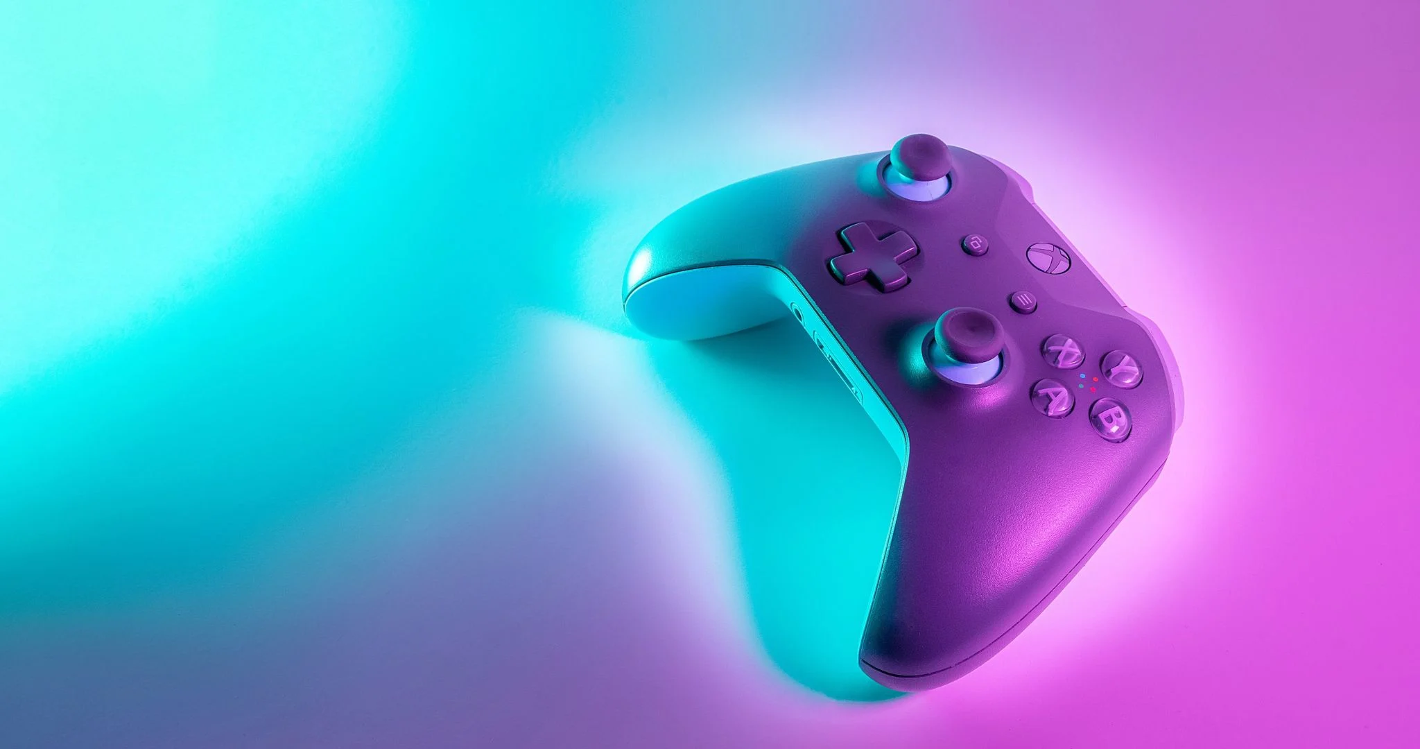 An Xbox controller under green and pink light. Source: Javier Martínez / Unsplash