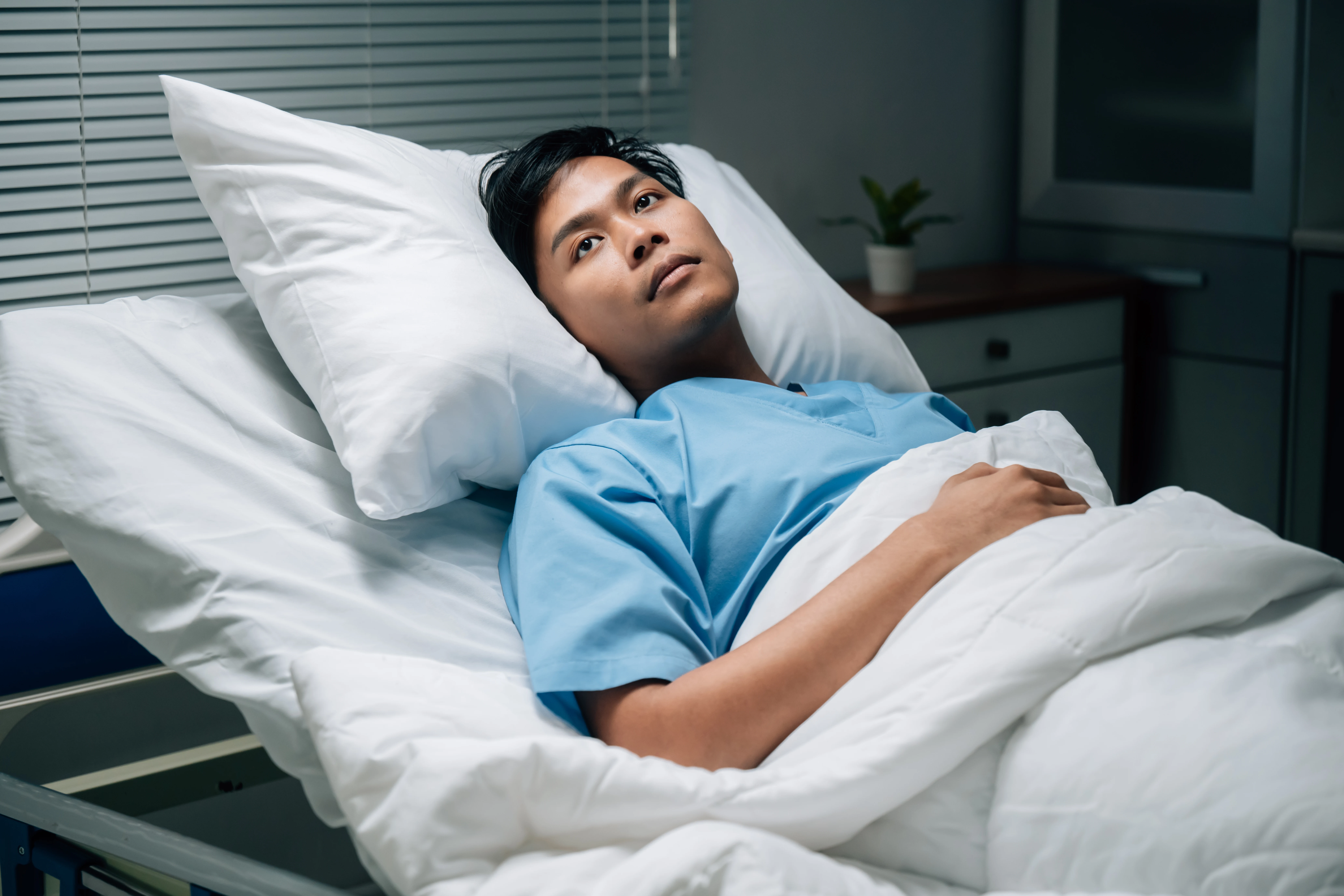 Pacient na lůžku se zotavuje zákroku v ústní dutině.