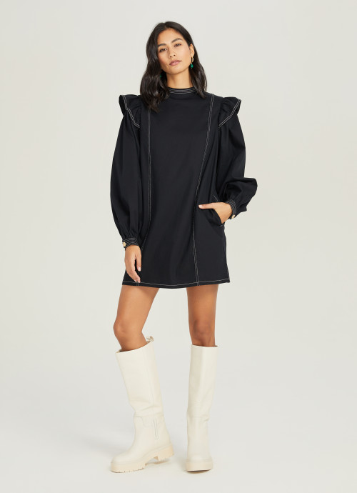 The Ruffle Shoulder Mini Dress in black with white boots