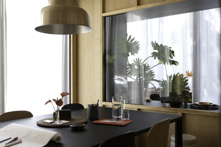 A lifestyle image of a dining scene from the Hem Headquarters in Stockholm, Sweden from 2018 featuring Touchwood Chairs, Levels Lamp, Log Table and Last Stool.