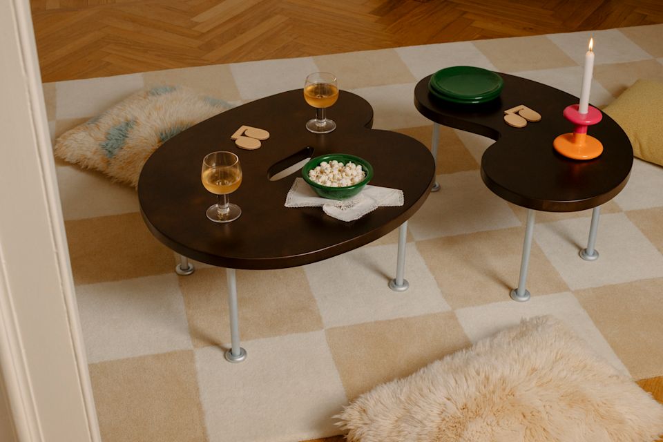 A lifestyle image of a living room/lounge scene featuring Worm Tables, Pattern Rug, Monster Cushions, Fars Glas, Disco Coasters, and Bronto Tableware.