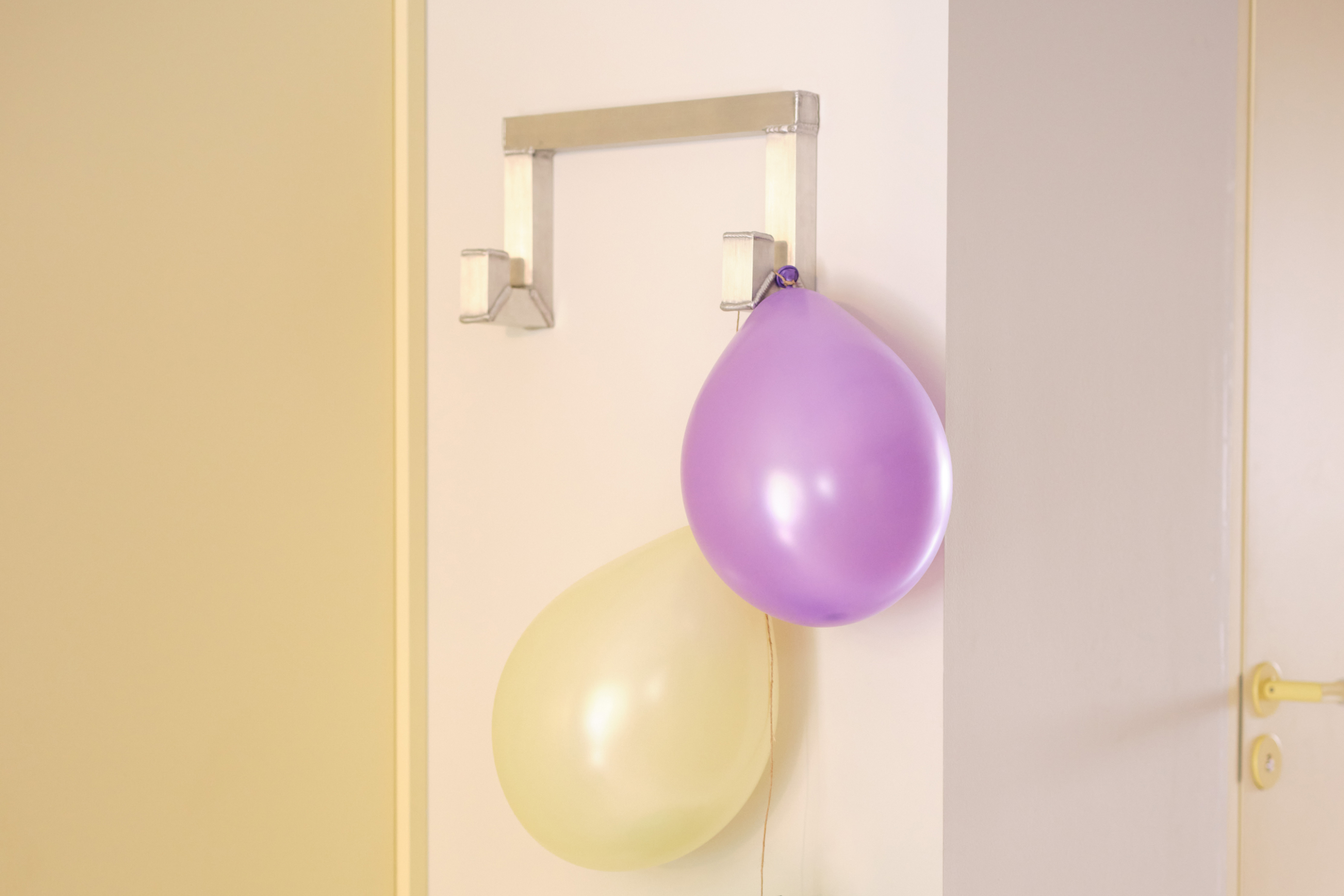 A lifestyle image featuring Tig Hook Double in a hallway with balloons hanging from it.