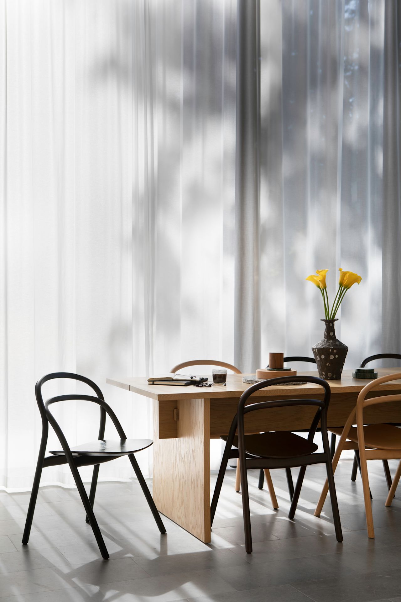 A lifestyle image of a dining scene featuring Bookmatch Table and Udon Chairs from the Hem Headquarters in Stockholm, Sweden from 2018.